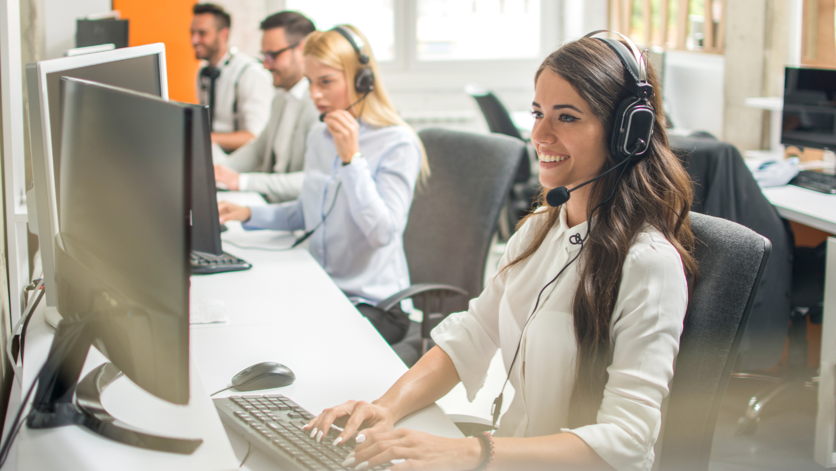 Several people working at a service desk. 