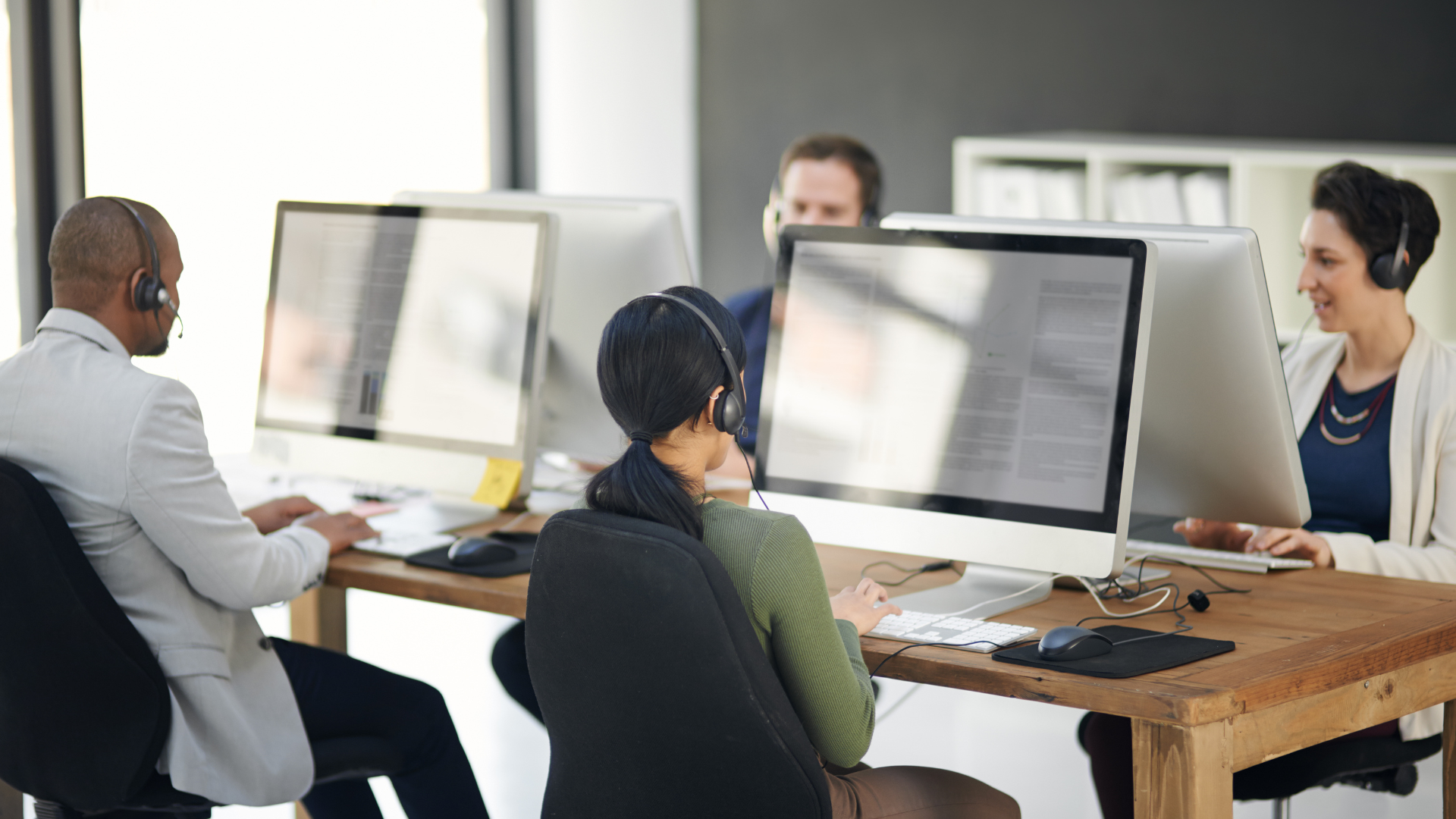 Several people working at a help desk. 