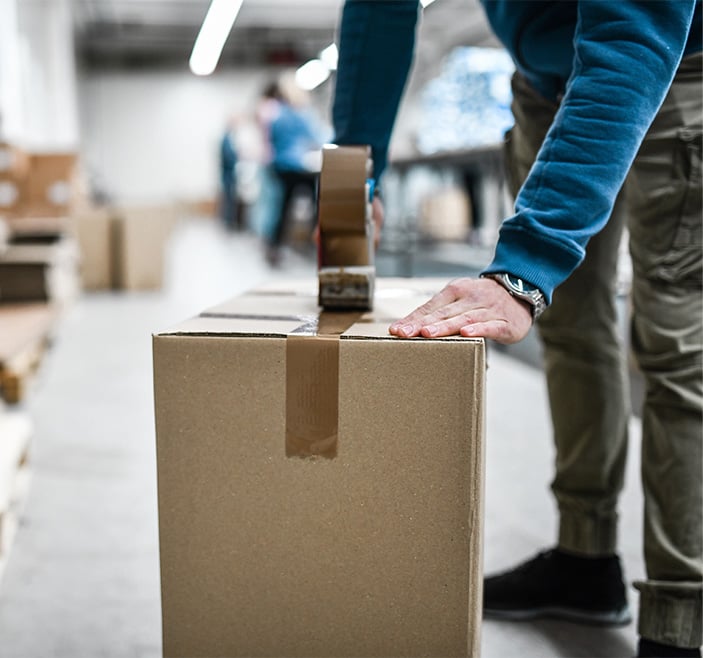 Man taping up a box. 