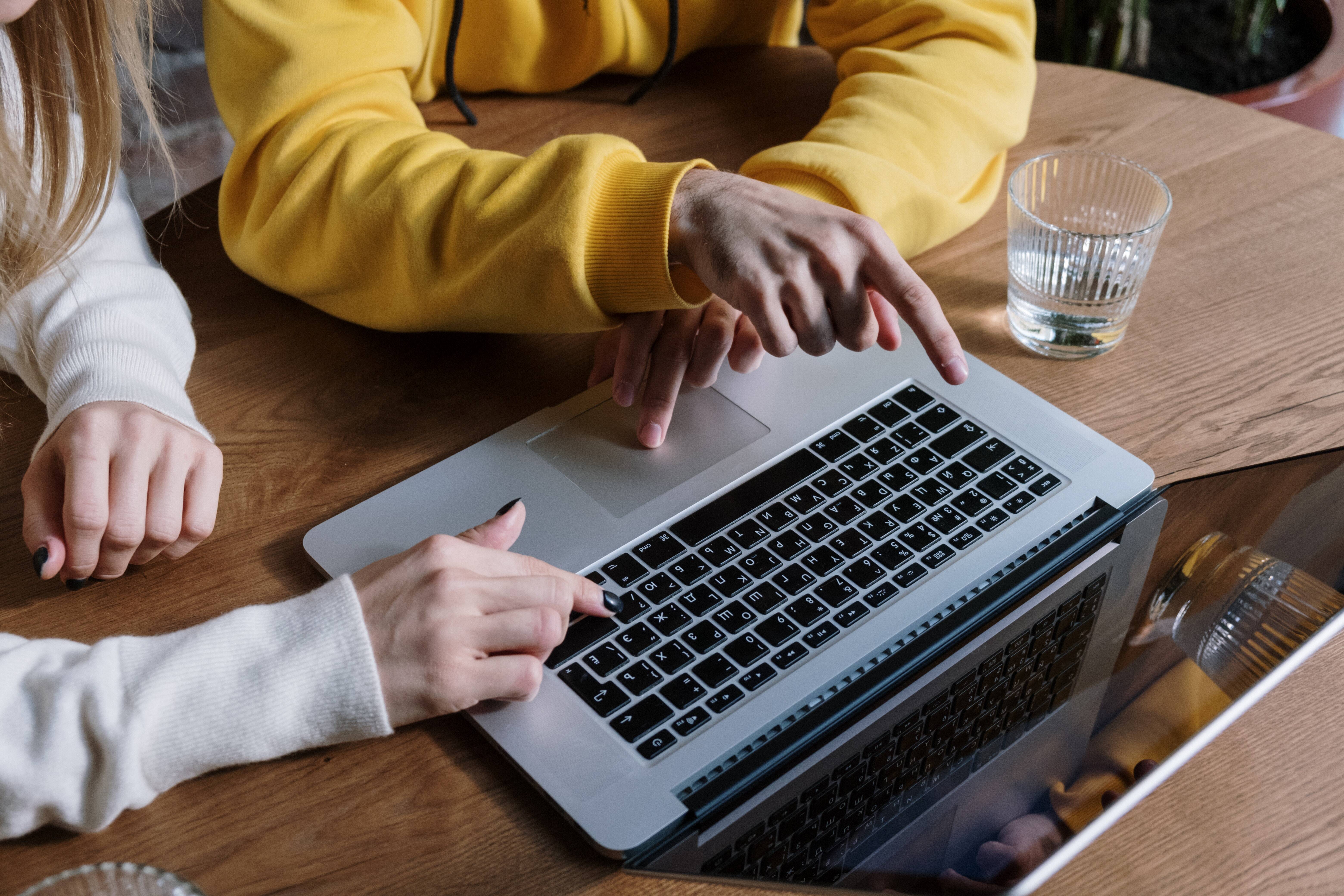 Two people using a laptop